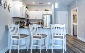 Clarksville apartment for rent - A kitchen with white chairs and a counter.