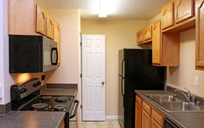 Louisville apartment for rent - A kitchen with a black fridge and stove.
