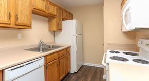 Louisville apartment for rent - A kitchen with wooden cabinets and white appliances.