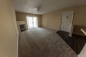 Louisville apartment for rent - an empty living room with a fireplace and a white door