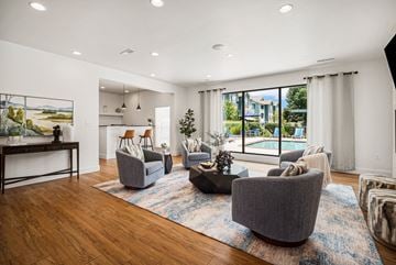 St. Peters apartment for rent - A living room with a large painting on the wall and a view of a pool outside.