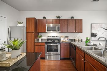 A kitchen with wooden cabinets and a black countertop.