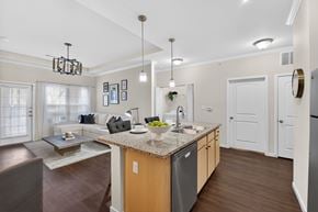 St. Louis townhouse for rent - A modern kitchen with a granite countertop and a dining area with a table and chairs.