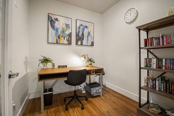 A room with a desk, chair, and bookshelf.