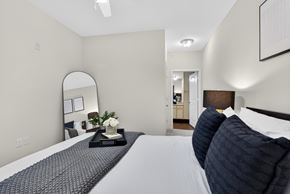 St. Louis townhouse for rent - A bedroom with a large bed and a mirror on the wall.