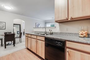 Lafayette apartment for rent - A kitchen with wooden cabinets and a black dishwasher.Plantation Crossing, Lafayette, LA, 70508