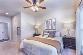 Chesterfield apartment for rent - a bedroom with a large bed and a ceiling fan at Aventura at Wild Horse Creek, Chesterfield, MO, 63017