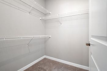 An empty closet with white walls and a white door