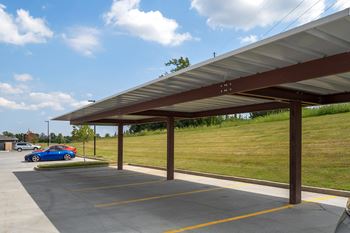 A parking lot with a car parked under a canopy