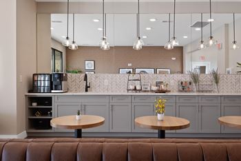 A modern cafe with brown leather booths and wooden tables.