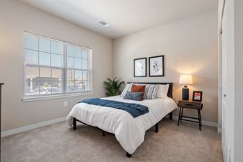 A bedroom with a bed next to a window