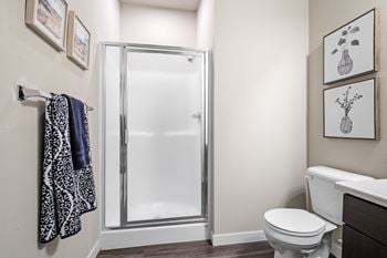 A bathroom with a shower and toilet in a 555 waverly unit