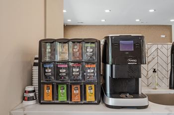A coffee machine is on a counter next to a box of coffee pods.