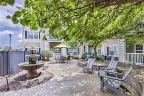 St.Louis townhouse for rent - a courtyard with a fountain and benches in front of a building at Aventura at Forest Park, St. Louis
