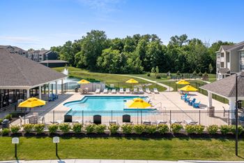 A large swimming pool surrounded by yellow umbrellas and blue loungers.