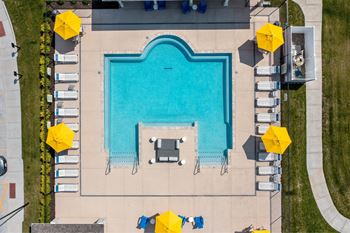 A large rectangular pool surrounded by yellow umbrellas and lounge chairs.