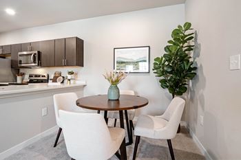 A modern kitchen with a dining table and chairs.