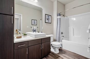 A bathroom with a white sink, toilet, and bathtub.