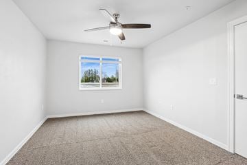 Sturgeon Bay apartment for rent - A room with a ceiling fan and carpeted floor.