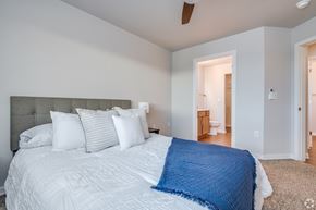 Kaukauna apartment for rent - A bedroom with a large bed and a ceiling fan.