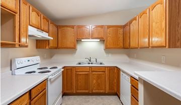 Green Bay apartment for rent - a kitchen with white appliances and wooden cabinets