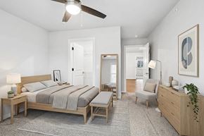 Sturgeon Bay apartment for rent - A bedroom with a bed, a chair, and a ceiling fan.