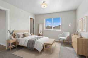 De Pere townhouse for rent - A bedroom with a bed, chair, and dresser.