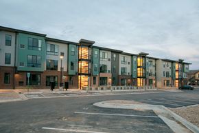 Lakewood apartment for rent - A row of modern apartment buildings are shown with a person walking in the foreground.