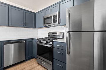 Holland apartment for rent - A modern kitchen with dark blue cabinets and stainless steel appliances.