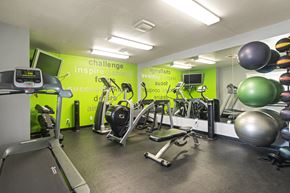 Kalamazoo apartment for rent - A gym with a green wall that says "challenge inspire succeed".