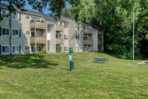 Kalamazoo apartment for rent - a grassy area with a picnic table in front of an apartment building
