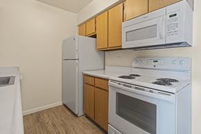 Kalamazoo apartment for rent - A white stove and microwave are installed above a white refrigerator in a kitchen.