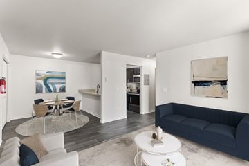 Kalamazoo apartment for rent - A living room with a white couch and a glass table.