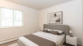 Kalamazoo apartment for rent - A bedroom with a large bed and a picture on the wall.