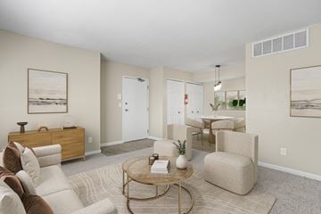 Kalamazoo apartment for rent - A living room with a brown sofa, a coffee table, and a painting on the wall.