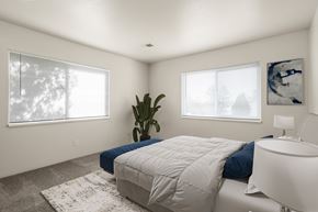 Kalamazoo apartment for rent - A bedroom with a large bed and a plant.