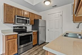 Grandville apartment for rent - a kitchen with stainless steel appliances and wooden cabinets