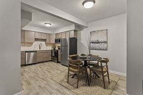 Grand Rapids apartment for rent - a kitchen and dining area with stainless steel appliances and a table and chairs