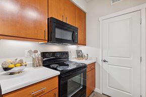 Richland apartment for rent - A kitchen with a black microwave above a stove and wooden cabinets.