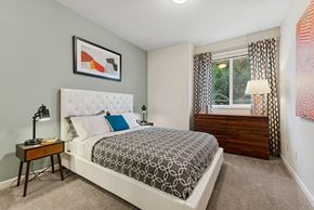 Kennewick apartment for rent - A bedroom with a large bed and a window with curtains.