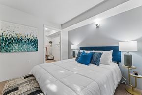 Spokane Valley apartment for rent - A bedroom with a white bed and blue pillows.