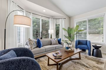 Kennewick apartment for rent - A living room with a grey couch, a blue armchair, a wooden coffee table, and a floor lamp.