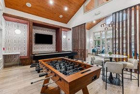Richland apartment for rent - A shiny pool table is in the middle of a room with a bar and a television.