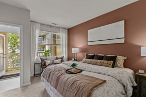 West Greenwich apartment for rent - A bedroom with a large bed and a window overlooking a balcony.