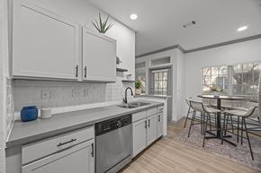San Antonio apartment for rent - A modern kitchen with white cabinets and a wooden floor.