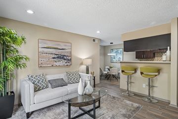 Fort Worth apartment for rent - A living room with a white couch, a coffee table, and a painting on the wall.