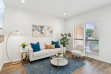 Irving apartment for rent - A living room with a white couch, a coffee table, and a painting on the wall.