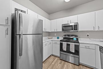 Mckinney apartment for rent - A kitchen with a stainless steel refrigerator and a microwave oven.
