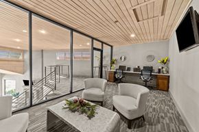 Dallas apartment for rent - A modern living room with a wooden ceiling and a glass wall leading to a balcony.