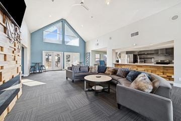 Dallas apartment for rent - A modern living room with a grey couch and a round coffee table.